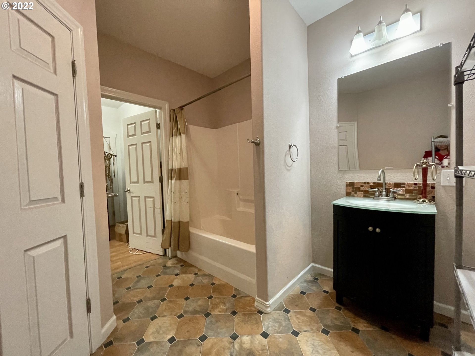 66325 North Bay Road North Bend, OR 97459 - Photo 25 of 31 a bathroom with a sink a mirror and a shower