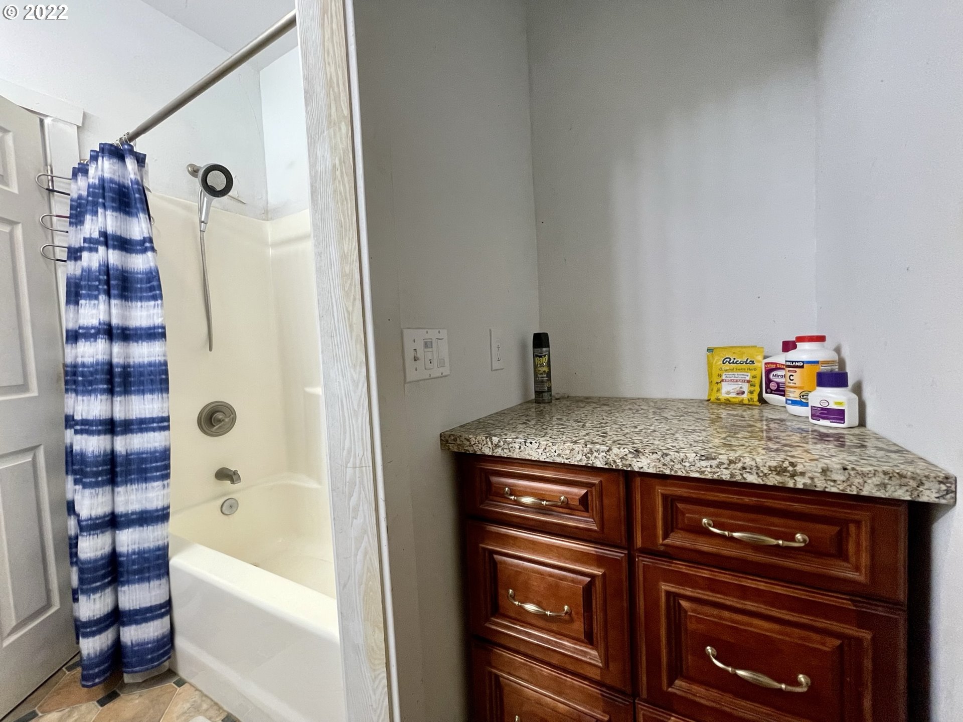 66325 North Bay Road North Bend, OR 97459 - Photo 27 of 31 a bathroom with a granite countertop sink and a bathtub