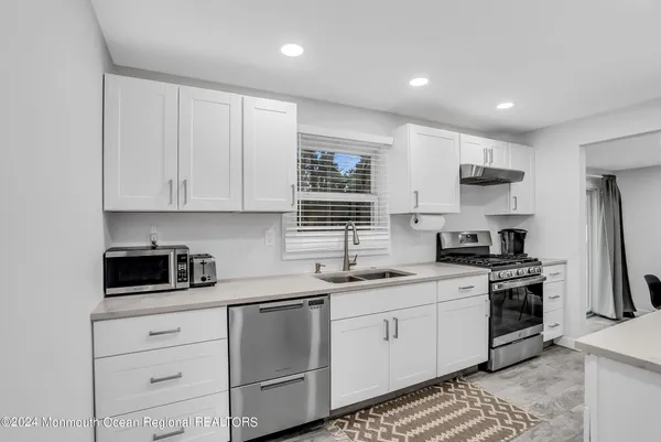 a kitchen with white cabinets stainless steel appliances and sink