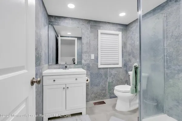 a bathroom with a toilet sink and mirror