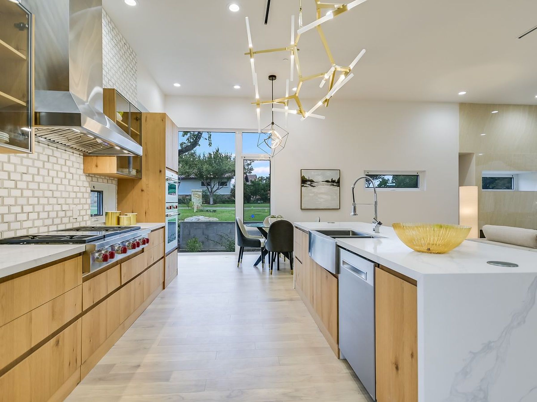 2476 Waymaker Way Austin, TX 78746 - Photo 8 of 31 Culinary excellence meets modern design in this spacious kitchen, boasting an island with a sink and sweeping backyard views.