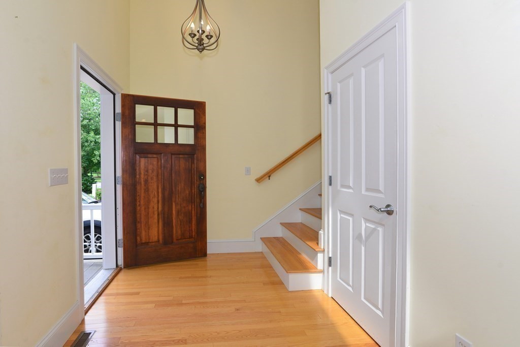 a view of a hallway with wooden floor and entryway