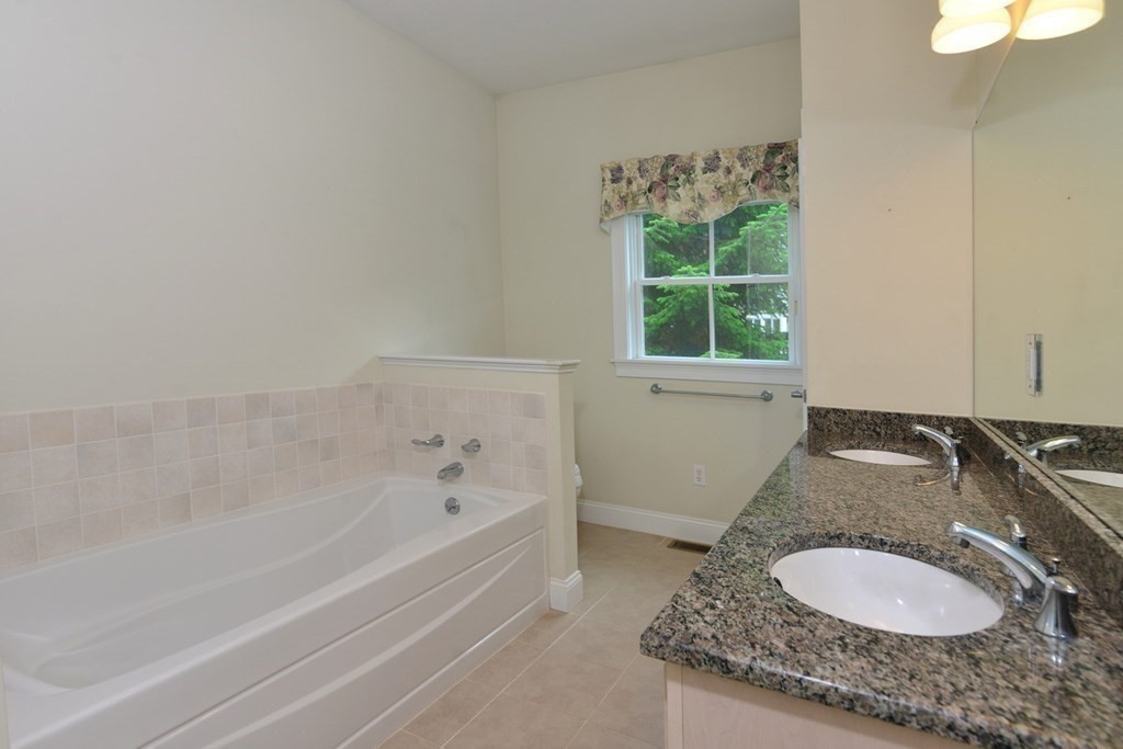 15 Hathaway Pond Circle, Unit 15 Rochester, MA 02770 - Photo 15 of 36 a bathroom with a granite countertop sink and a mirror