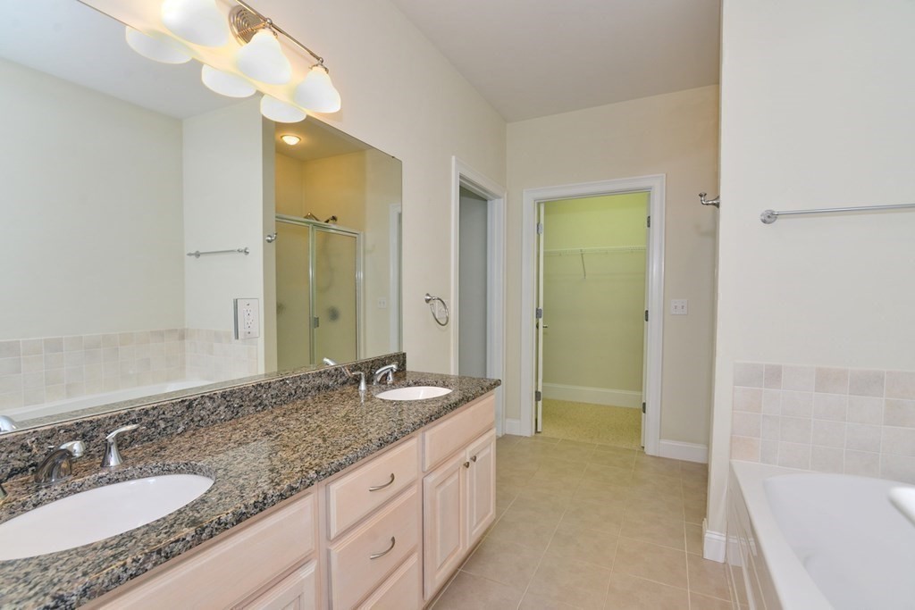 15 Hathaway Pond Circle, Unit 15 Rochester, MA 02770 - Photo 16 of 36 a bathroom with a granite countertop double vanity sink mirror and a bathtub