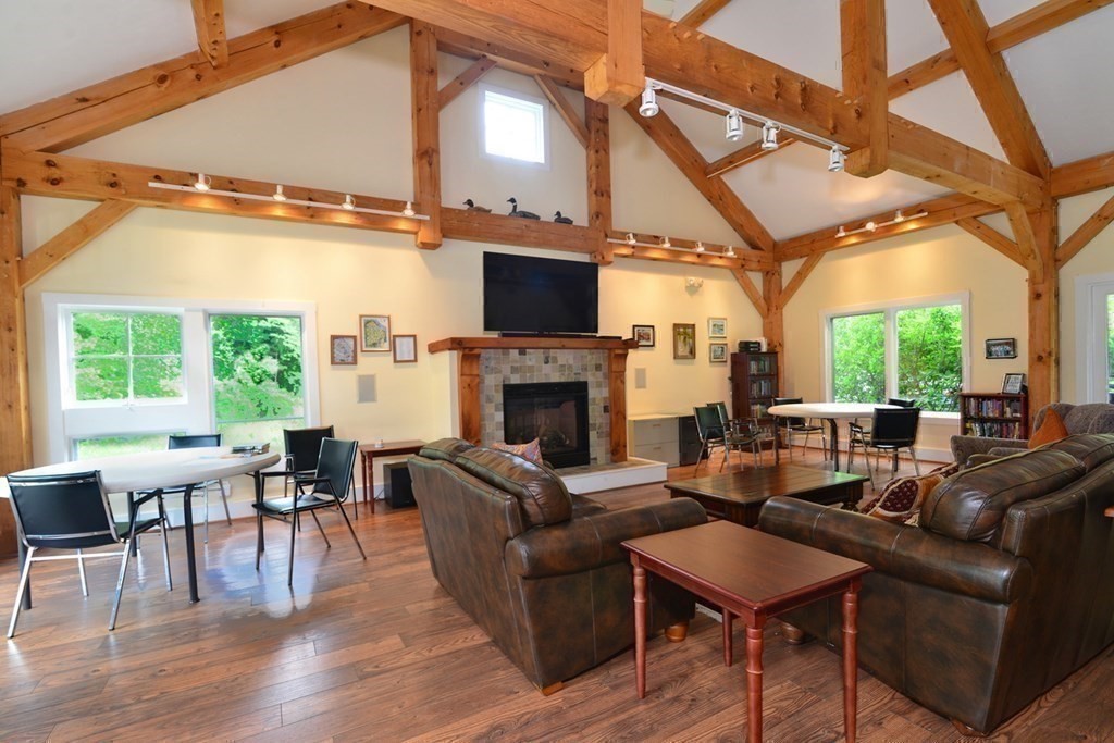 15 Hathaway Pond Circle, Unit 15 Rochester, MA 02770 - Photo 27 of 36 a living room with furniture a fireplace and a flat screen tv