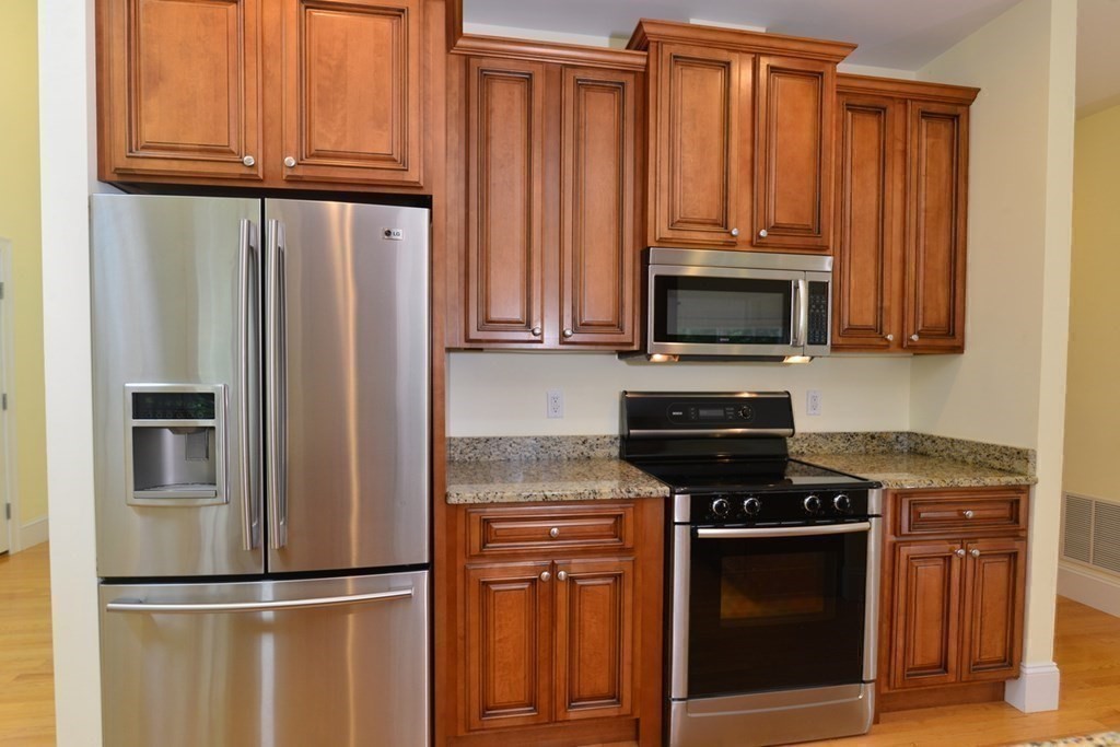 15 Hathaway Pond Circle, Unit 15 Rochester, MA 02770 - Photo 8 of 36 a kitchen with stainless steel appliances granite countertop a refrigerator stove and microwave