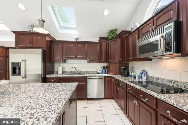 a kitchen with stainless steel appliances granite countertop a sink stove and microwave