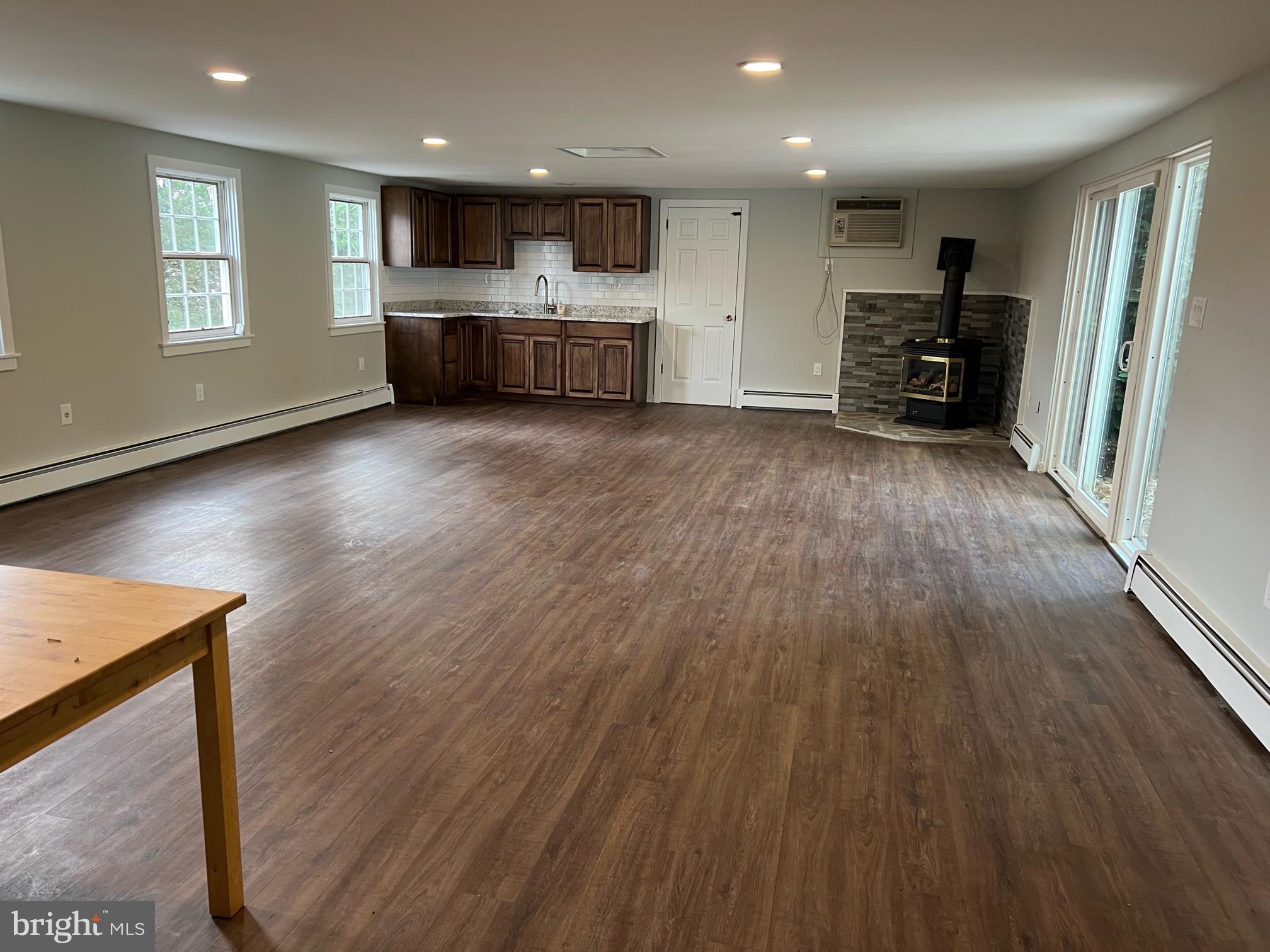 908 Lincoln Road Phoenixville, PA 19460 - Photo 13 of 26 an empty room with wooden floor kitchen view and a window