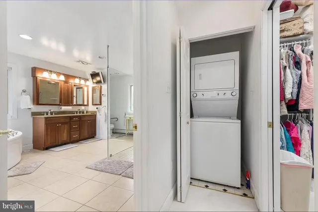 a large white kitchen with a sink stainless steel appliances and cabinets