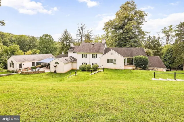 a view of a house with pool and a yard