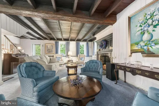 a living room with fireplace furniture and a large window