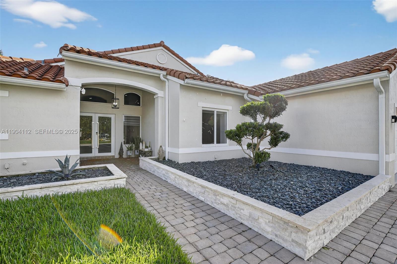 18950 Southwest 16th Street, Unit 1950 Pembroke Pines, FL 33029 - Photo 2 of 51 a front view of a house with garden