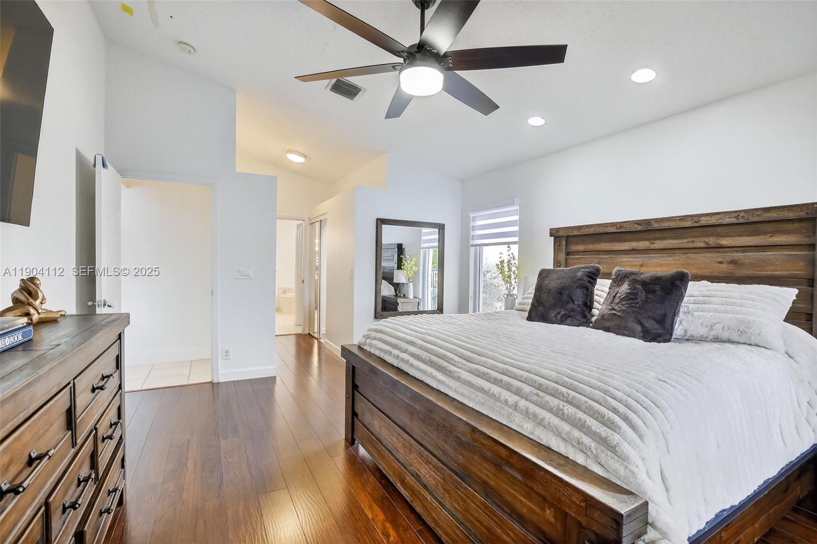 18950 Southwest 16th Street, Unit 1950 Pembroke Pines, FL 33029 - Photo 25 of 51 a bedroom with a bed and a chandelier