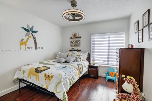 a bedroom with a bed and a wooden floor