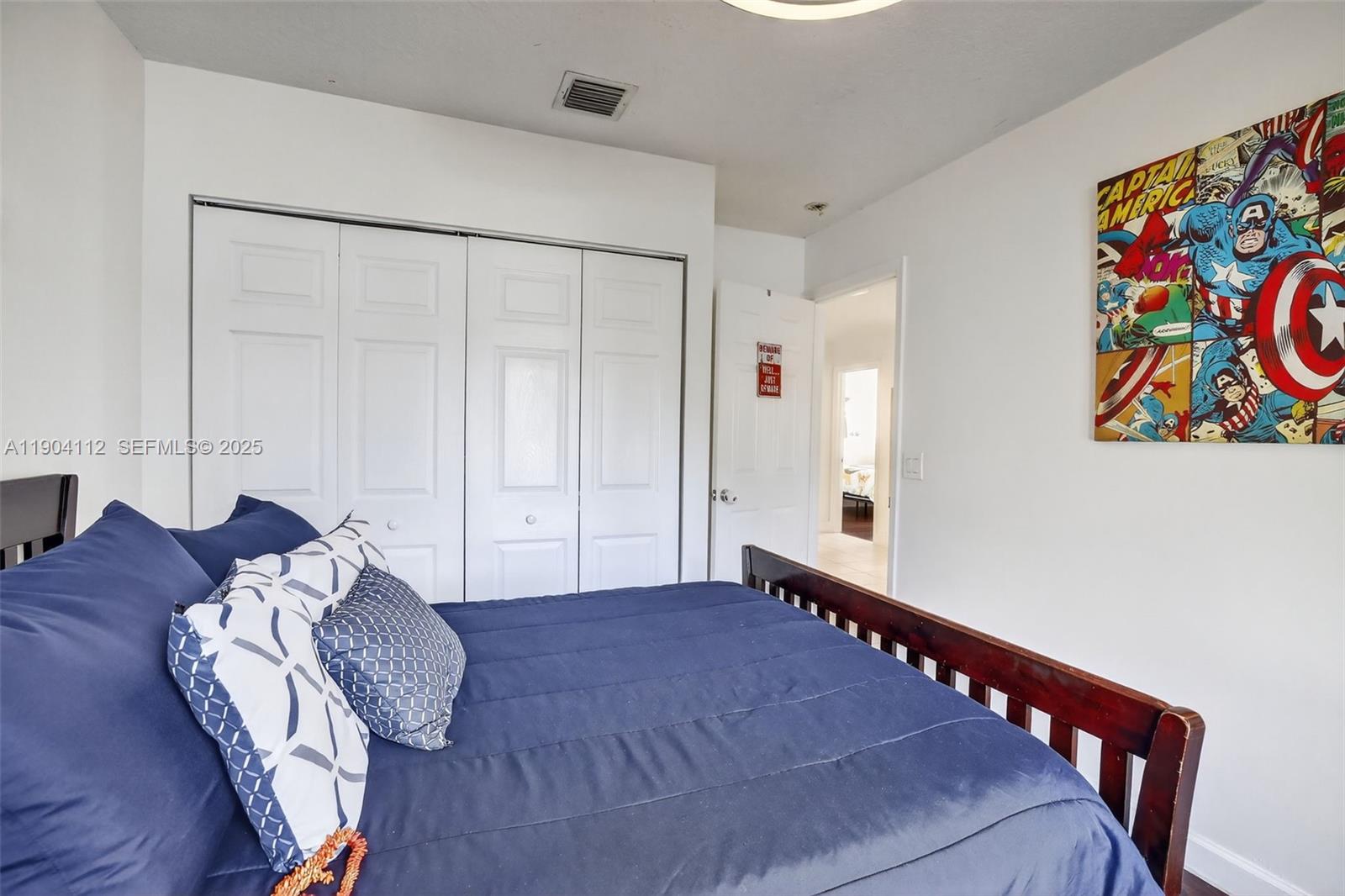 18950 Southwest 16th Street, Unit 1950 Pembroke Pines, FL 33029 - Photo 39 of 51 a bedroom with a bed and a painting on the wall