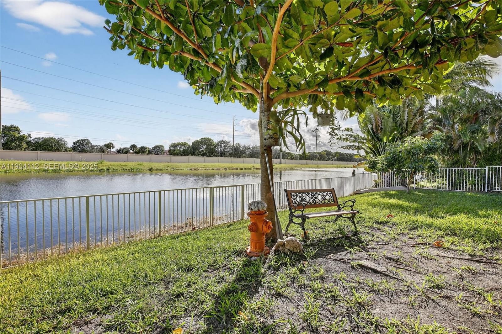 18950 Southwest 16th Street, Unit 1950 Pembroke Pines, FL 33029 - Photo 40 of 51 a view of a bench in the garden near a lake