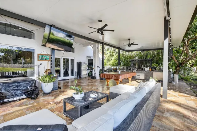a living room with patio furniture and a floor to ceiling window