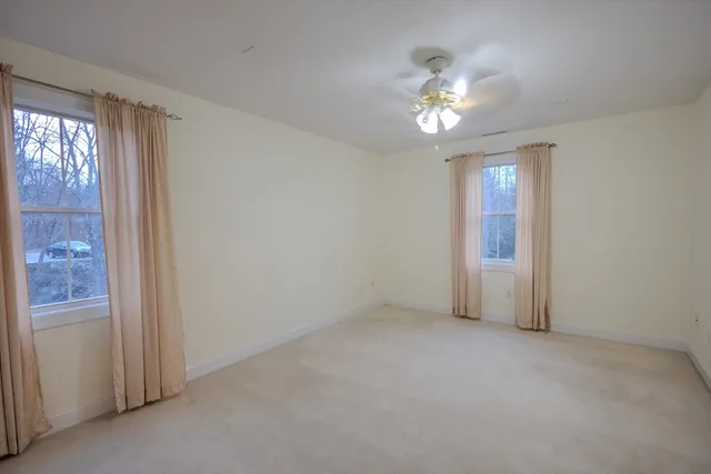 a view of a livingroom with a ceiling fan and window