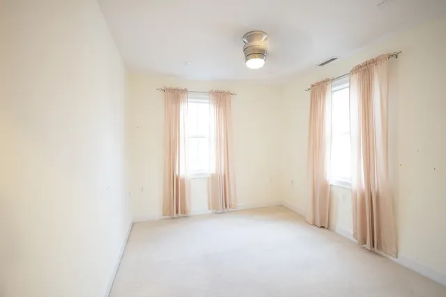 an empty room with windows and closet