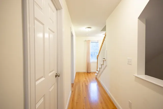 a view of a hallway with wooden floor and staircase