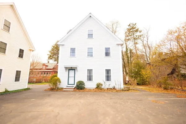a view of a white house with a road