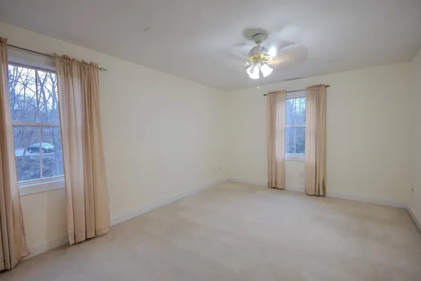 a view of a livingroom with a ceiling fan and window