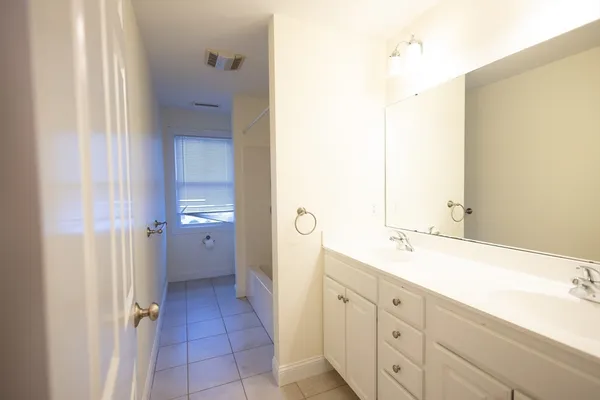 a spacious bathroom with a double vanity sink a mirror and a shower