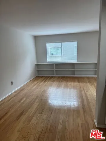 a view of room with wooden floor and white walls