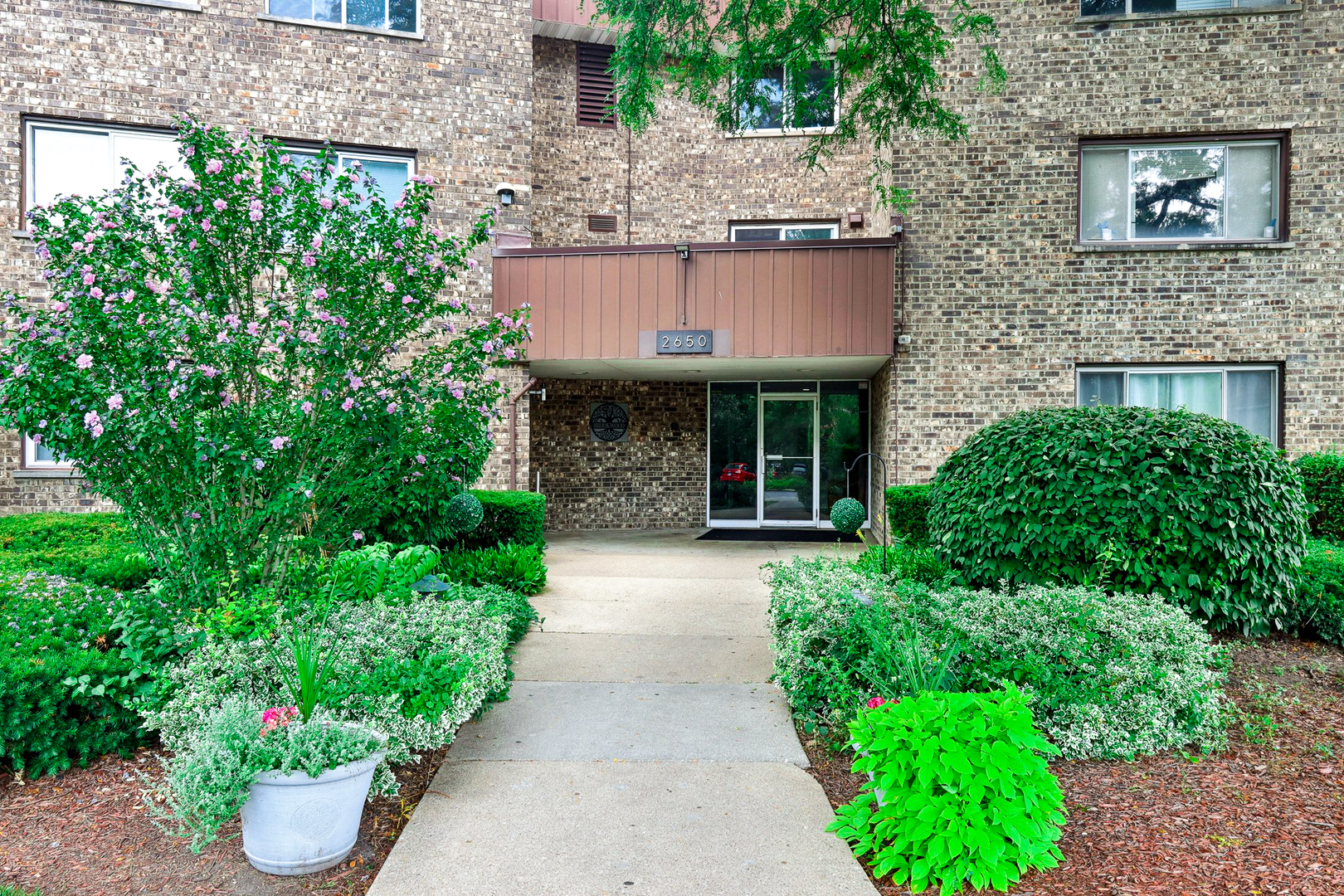 2650 Brookwood Way Drive, Unit 201B Rolling Meadows, IL 60008 - Photo 3 of 25 a view of a house with potted plants and a fountain