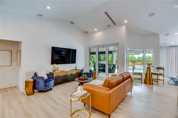 a living room with furniture a flat screen tv and a large window