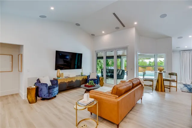 a living room with furniture a flat screen tv and a large window