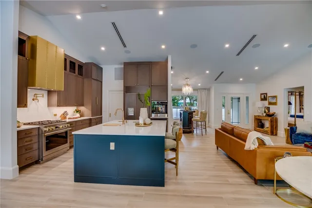 a living room with stainless steel appliances kitchen island granite countertop furniture wooden floor and a view of kitchen
