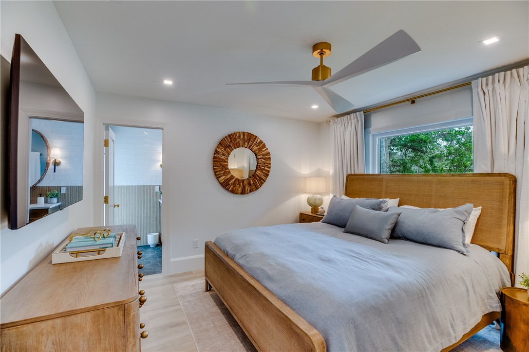 700 Holly Road Vero Beach, FL 32963 - Photo 24 of 36 a bedroom with a large bed and a large mirror