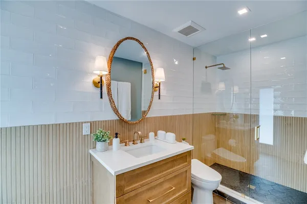 a bathroom with a sink mirror vanity and toilet