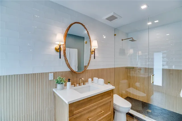 a bathroom with a sink mirror vanity and toilet
