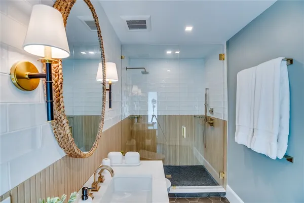 a bathroom with a sink a light fixture and a mirror