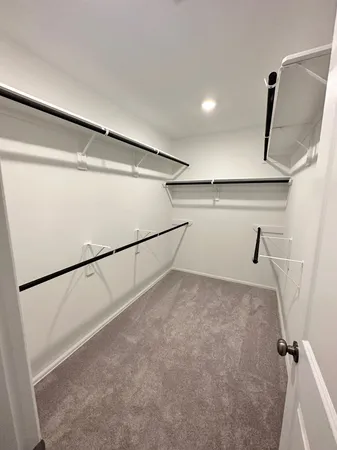 a view of walk in closet with empty racks