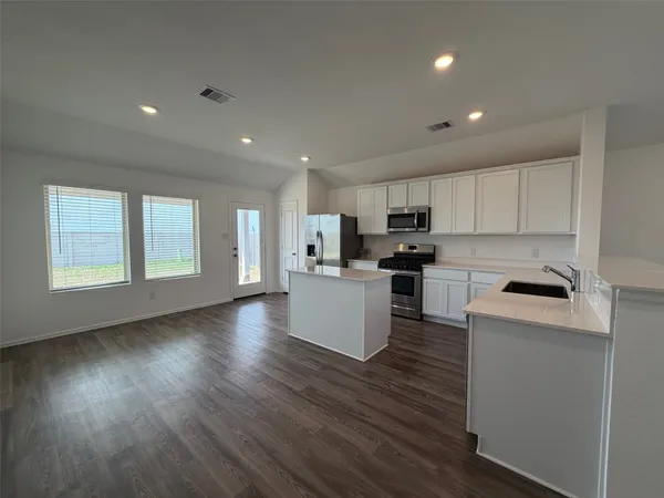 a kitchen with stainless steel appliances granite countertop a stove a sink a refrigerator and a microwave