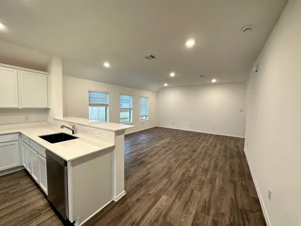 a kitchen with a sink and wooden floor