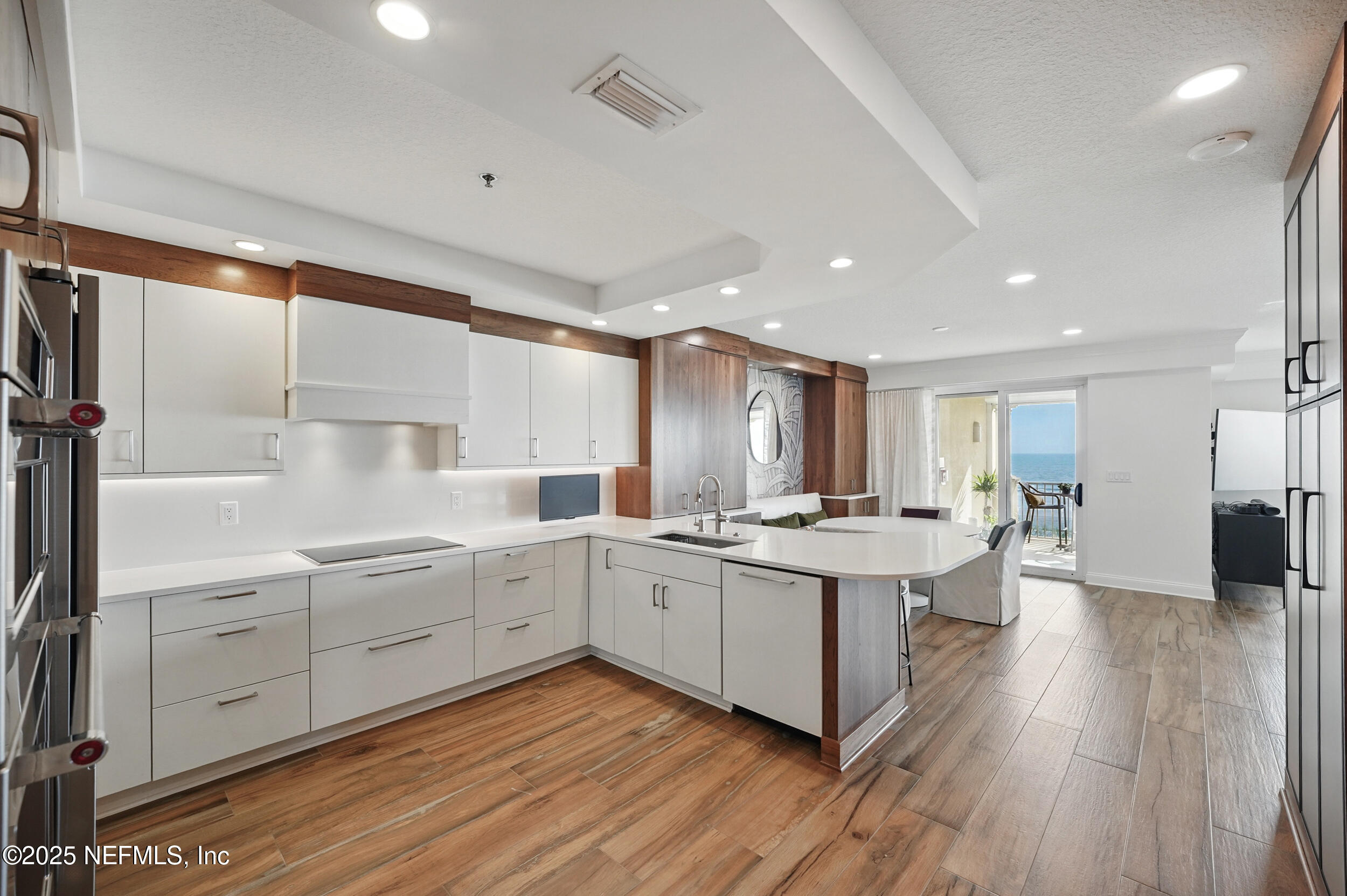 1505 1st Street South, Unit 302 Jacksonville Beach, FL 32250 - Photo 7 of 57 a large kitchen with a lot of counter space and wooden floor
