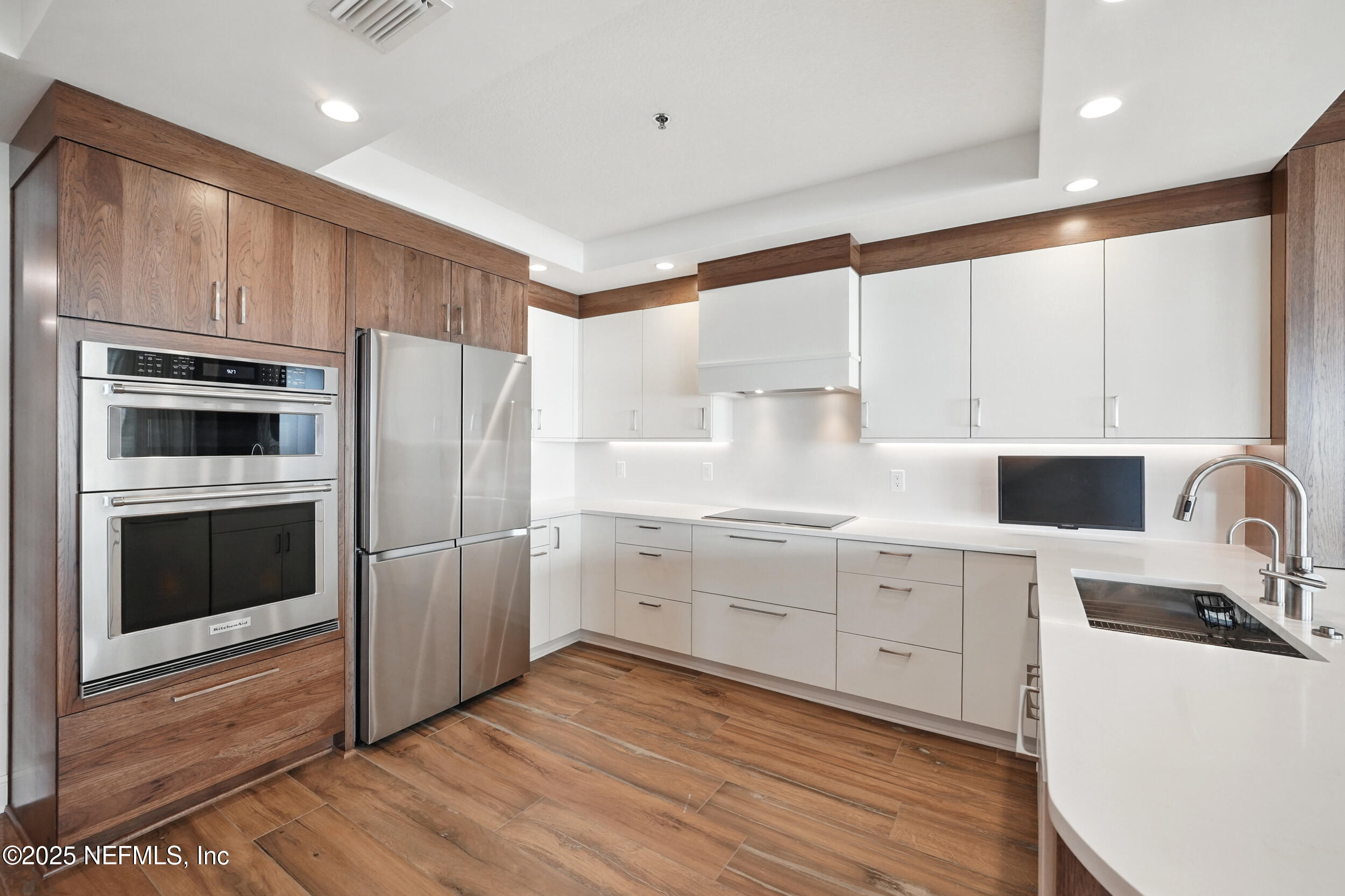 1505 1st Street South, Unit 302 Jacksonville Beach, FL 32250 - Photo 9 of 57 a kitchen with cabinets stainless steel appliances a sink and wooden floor