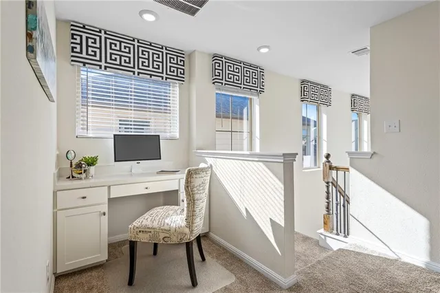 a view of a workspace with furniture and a window