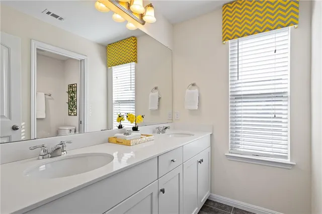 a bathroom with a double vanity sink and a window