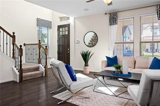 a living room with furniture a wooden floor and a large window