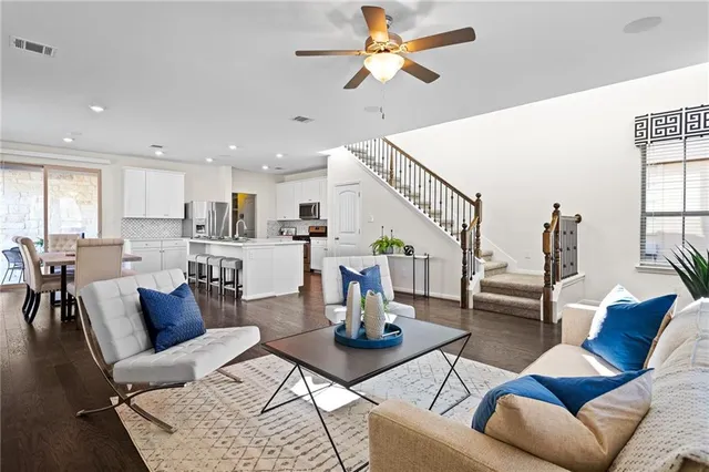a living room with furniture kitchen view and a chandelier