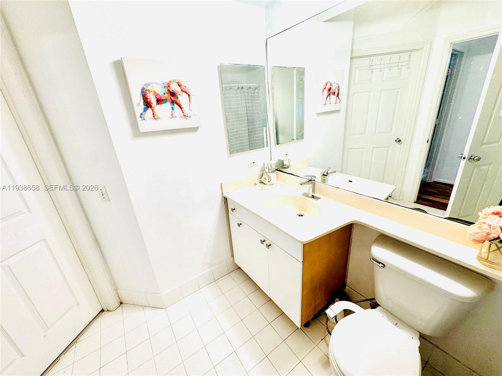 17150 North Bay Road, Unit 2412 Sunny Isles Beach, FL 33160 - Photo 15 of 29 a bathroom with a sink mirror vanity and toilet