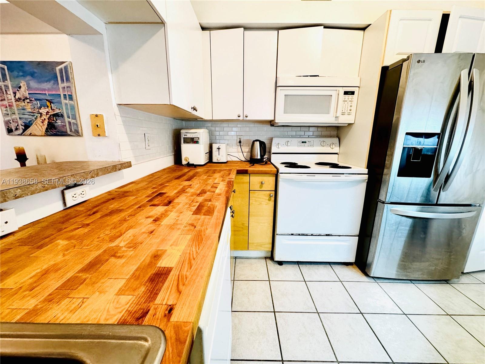 17150 North Bay Road, Unit 2412 Sunny Isles Beach, FL 33160 - Photo 3 of 29 a kitchen with stainless steel appliances a stove a sink and a refrigerator
