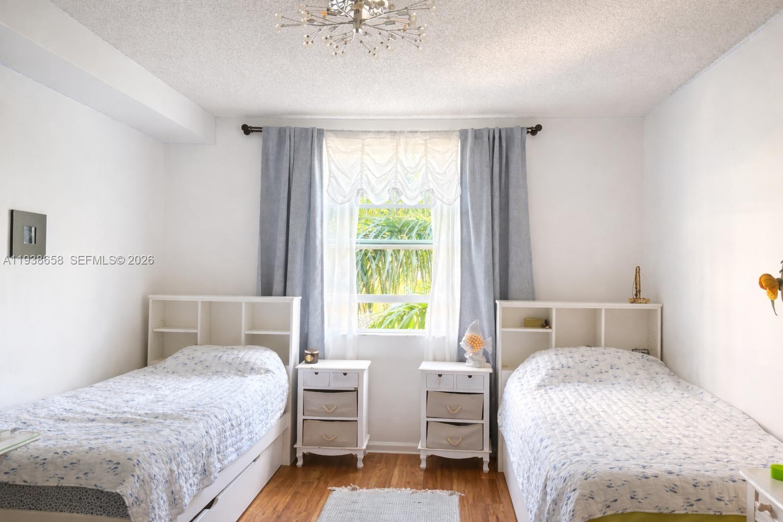 17150 North Bay Road, Unit 2412 Sunny Isles Beach, FL 33160 - Photo 7 of 25 a bedroom with a bed and wooden floor