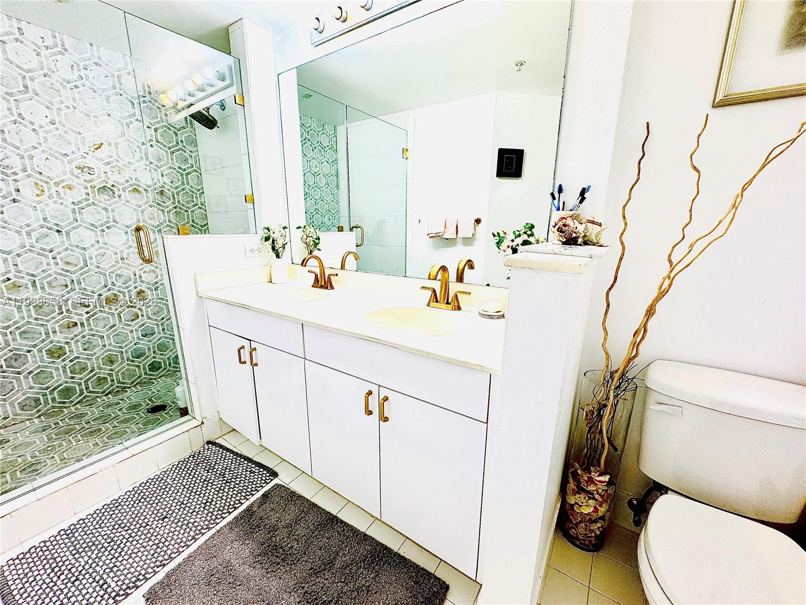 17150 North Bay Road, Unit 2412 Sunny Isles Beach, FL 33160 - Photo 8 of 29 a bathroom with a sink a toilet and mirror