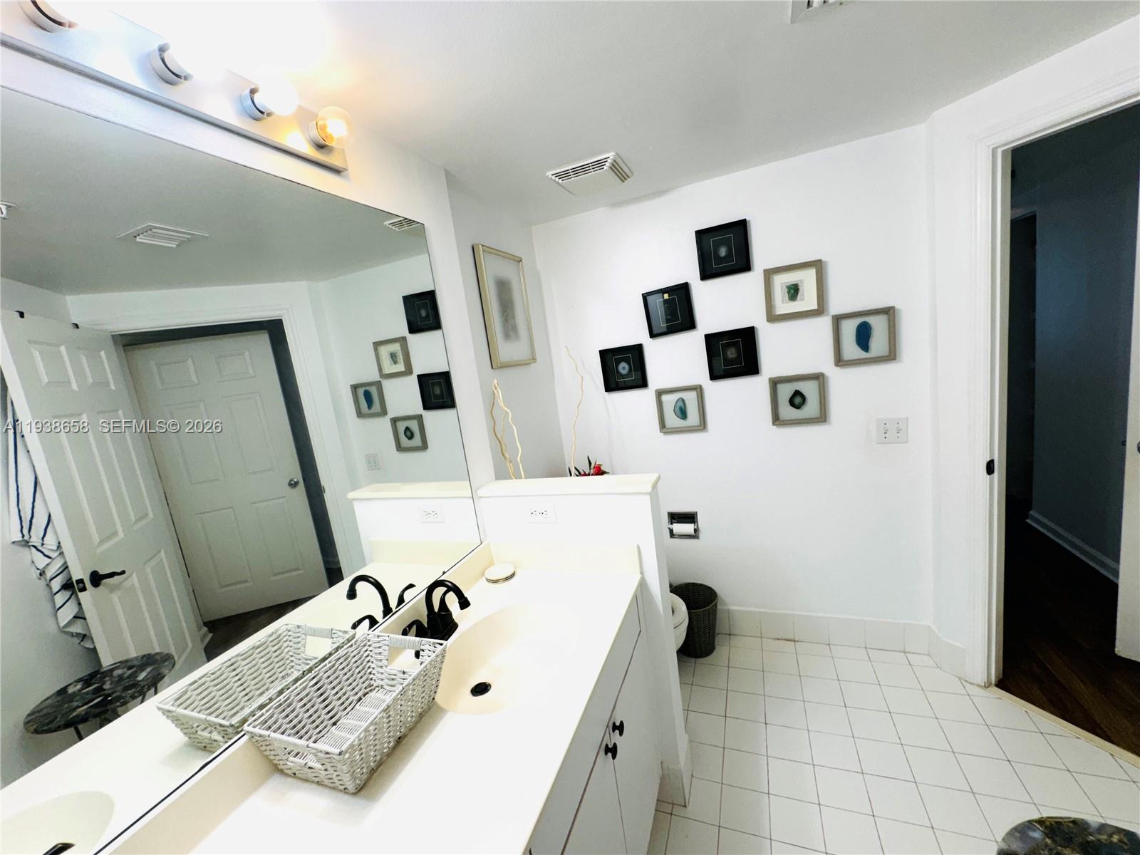 17150 North Bay Road, Unit 2412 Sunny Isles Beach, FL 33160 - Photo 10 of 29 a bathroom with a sink a toilet and a mirror